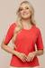 Blusa canelada feminina de verão cor coral com destaque para uma tira com botão dourado aplicados na manga.
