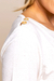 Detalhe da blusa feminina de verão em crepe linho, mostrando a parte do ombro com botões dourados.