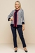 Modelo vestindo cardigan listrado em marinho e branco com detalhes vermelhos e calça azul marinho