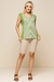 Modelo usando uma regata listrada verde com detalhes em off white, formando um look casual e confortável combinada com bermuda bege.