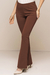 Calça flare bodycon na cor marrom, com detalhe de cós infinito na cintura e corte justo até os joelhos, abrindo em uma perna larga.