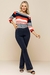 Modelo usando calça flare bodycon de cor azul marinho, com blusa listrada em vermelho e branco, posando de forma elegante.