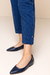 Detalhe da barra de uma calça Capri jacquard feminina em linho na cor azul marinho, com destaque para um botão dourado aplicado em cima de um martingale