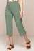 Calças Capri Bodycon na cor verde, com detalhes na barra e usadas com sandálias de salto.
