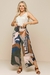 Pantacourt Wave Estampada com estampas geométricas em tons de verde, marrom e bege, compondo um look moderno com regata de linho.
