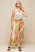 Modelo vestindo pantacourt estampada em tons de verde e laranja, combinada com uma regata de linho off white, em um look alegre e elegante de verão