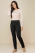 Modelo usando calça thermo tradicional preta com uma blusa de manga longa bege, look confortável inverno 2025