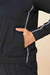 Detalhe do conjunto thermo texturizado com pantalona, mostrando a mão dentro do bolso da jaqueta preta.
