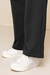 Detalhe do conjunto Thermo texturizado com pantalona, mostrando a parte inferior da pantalona preta.
