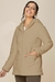 Casaco Sherpa com capuz, na cor bege apresentando detalhes de zíper e bolsos frontais, modelo feminino de inverno 2025 La Thereza.