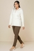 Look de inverno com casaco sherpa branco com capuz, calças marrons e tênis. Moderno e confortável.