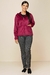 Look de inverno com casaco veludo canelado na cor rosa, com calças cinzas e tênis escuros.