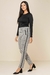 Calça jogger jacquard em preto e branco, com detalhes em zíper, combinada com uma blusa preta, destacando um estilo moderno e confortável.