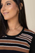 Modelo usando blusa visco listrada com listras em preto, marrom e branco, destacando o decote redondo.