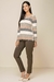 Modelo vestindo uma blusa visco listrada em tons neutros e calça marrom, look confortável de inverno