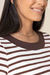 Detalhe da blusa tricot listrada com gola marrom e listras brancas e marrons, destacando a modelagem e o acabamento.