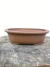 Vaso de cerâmica marrom para bonsai, modelo Literato, com formato oval e borda arredondada, medindo 18,6x13,2x5,6cm