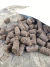 Pacote de Adubo Orgânico Ishiyama 500g com pellets marrons espalhados sobre uma superfície de madeira