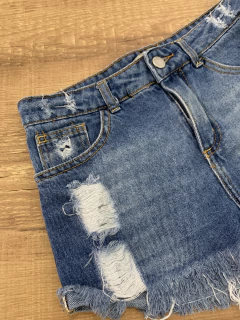 Short jeans azul com detalhes rasgados e barra desfiada (Miss Fifteen) - Babies Move Brecho