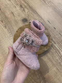 Botinha de pelucia rosa com aplicação de laço na internet