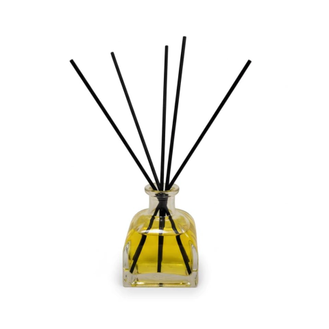 Difusor de ambiente Capilla con aroma a vainilla y coco en frasco de vidrio transparente con líquido amarillo y varillas negras