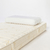 Colchón Naturalfoam de 100% látex natural con almohada blanca sobre él.