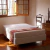 Base sommier Naturalfoam en una habitación iluminada, con ventana y mobiliario de madera.