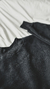 Detalles del buzo negro crop top de friza para mujer. Elástico en la cintura y cuello alto, ideal para un look moderno y abrigado.