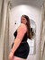 Mujer posando de perfil con un top negro y pantalones cortos de homewear en un vestidor.