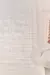 Tapete Nuvem Pérola em tom off white, com textura geométrica, posicionado ao lado de um sofá claro.