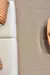 Tapete sisal marrom em uma sala com sofá claro e almofada laranja, mostrando textura e ambiente aconchegante.