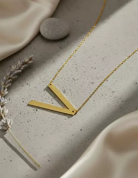 Collar con letra inclinada acero dorado - comprar en línea