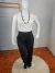 Calça plus size alinhada com cinto, modelo feminino, com blusa branca e colar, exibida em manequim.