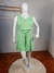 Conjunto plus size feminino na cor verde, composto por blusa de alça e shorts, exibido em um manequim sobre um tapete redondo.