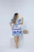 Vestido plus size branco com estampa azul, visto de costas, em ambiente claro.