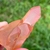 Mini drusa de quartzo tangerina em mãos, com tonalidades alaranjadas e transparentes.