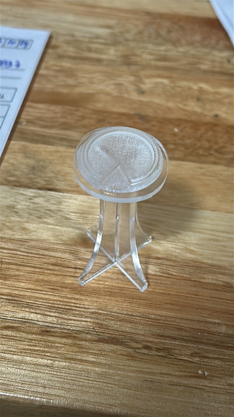 Sello de acrílico transparente para cerámica, arcilla y jabones, sobre una superficie de madera.
