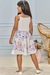 Menina usando vestido infantil kukiê florido em jacquard, com estampa de flores e ursos, vista de costas.