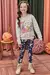 Menina sorridente usando um blusão de moletom cinza com estampa de animais e legging azul com desenhos coloridos.