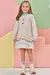 Menina sorridente vestindo um vestido em moletom linho, com capuz e estampas coloridas, em um fundo de cores suaves.