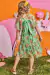Vestido infantil Kukiê em Tule Comfy, com estampa floral e detalhes em verde, visto de costas por uma menina.