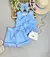 Conjunto infantil azul com blusa sem mangas e short listrado, acompanhado por um laço azul e uma bolsa branca.