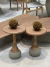 Mesa lateral Ashta em madeira maciça e concreto com duas frutas decorativas em cima.