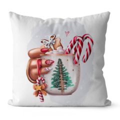 Capa de almofada com uma mão segurando uma caneca decorada com uma árvore de Natal, rodeada de doces de Natal e marshmallows.