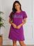 Mulher sorridente vestindo vestido curto roxo de algodão com estampa floral e frase "Cultivando Gratidão"