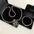 Conjunto de colar e pulseira banhados a prata, com pingente em forma de pentagrama.