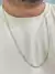 Corrente masculina banhada a ouro 18k com elos estilo tijolinho de 2mm, vista em um homem usando uma camiseta clara.