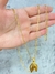 Corrente banhada a ouro 18k de 2 mm com pulsera e pingente em forma de ferradura, segurada na mão.