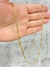 Corrente masculina banhada a ouro 18k, modelo Figaro 3 por 1, com espessura de 2mm, sendo segurada por uma mão.