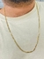 Corrente masculina banhada a ouro 18k no estilo Figaro 3 por 1, com espessura de 2mm, vista sobre uma camiseta clara.